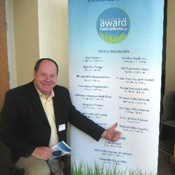 Man in front of the CoolCalifornia small business award winners banner.